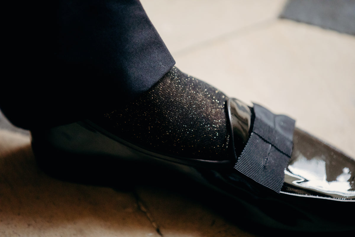 Chaussettes de couleur noir avec un effet léger de paillettes doré, en 80% coton, 10% polyamide, 10% polyester. Modèle de mi-bas (hautes) pour homme, de la marque Bresciani. Douces, fines et durables. Pointures : du 39 au 45